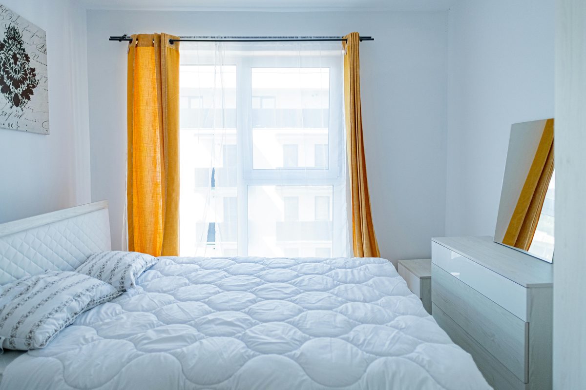 Dormitorio bien iluminado con colchón blanco en ambiente limpio y ordenado